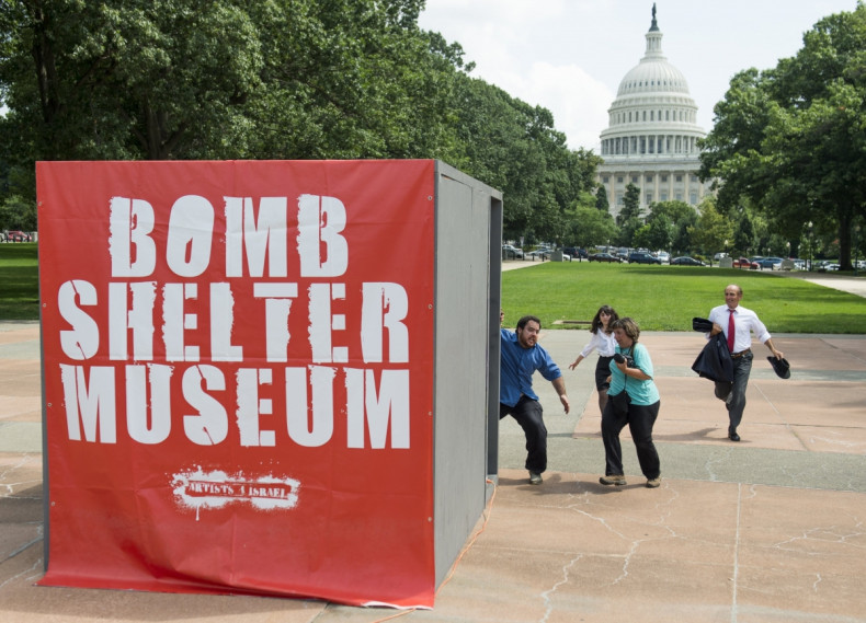 People run towards a mock bomb shelter during a simulated attack by Hamas rockets as part of a multimedia art exhibit called The Bomb Shelter Museum which is modeled after bomb shelters in Israel, near the US Capitol in Washington