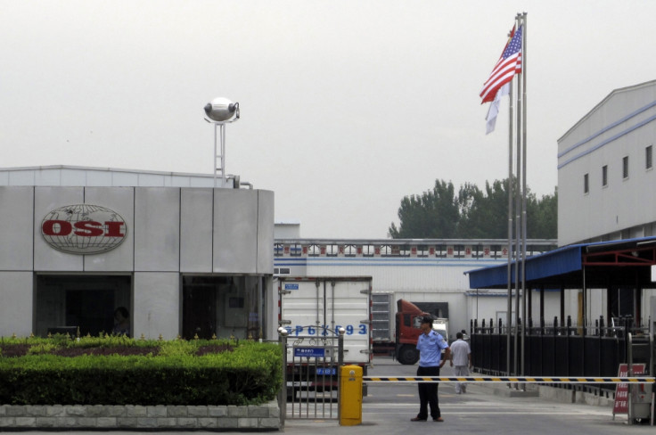 A security personnel stands guard in front of an OSI's food processing plants in Langfang, Hebei province