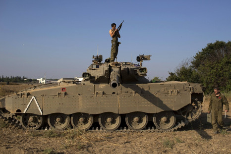 Israeli solider checks his weapon atop of a tank