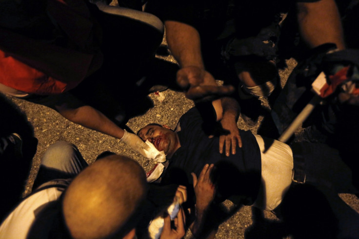 A wounded Palestinian protester lies on the ground during clashes with Israeli troops, at a protest against Israeli offensive in Gaza,