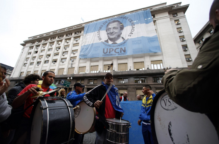 Pro-government demonstrators beat drums in front of an image of late President Nestor Kirchner placed over the Economy Ministry in Buenos Aires' financial district