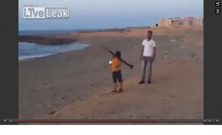 Still from the footage, showing a boy firing an RPG on a Libyan beach.