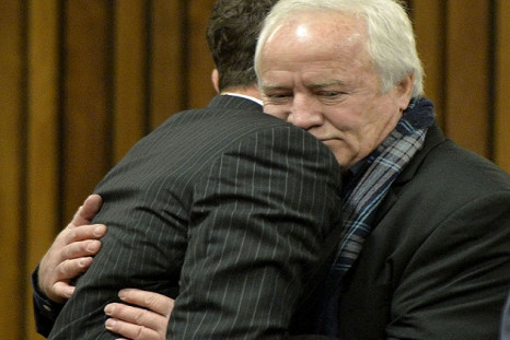 Henke Pistorius hugs his son Oscar in court during a rare appearance by the fallen idol's absent father