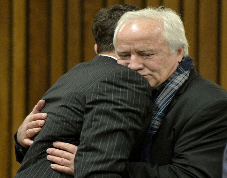 Henke Pistorius hugs his son Oscar in court during a rare appearance by the fallen idol's absent father