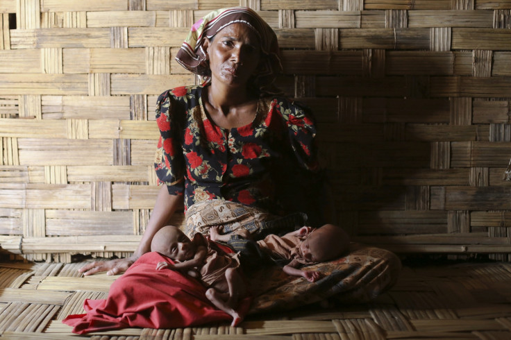 Displaced Rohingya woman Norbagoun carries her severely malnourished 25-day-old twins in her lap in their house at the Dar Paing camp for internally displaced people in Sittwe, Rakhine state