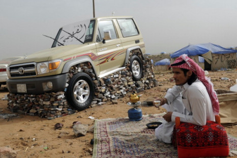 Saudi youth sits next to his SUV