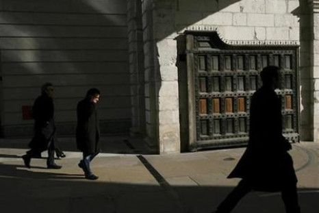 Pedestrians walk through the gate at Paternoster Square, home to the London Stock Exchange, London