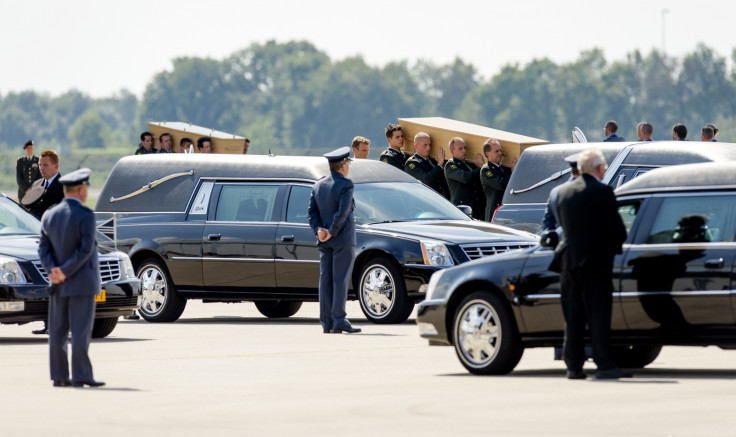 Dutch military personnel carry coffins containing victims of the MH17 crash to waiting hearses at Eindhoven Airport