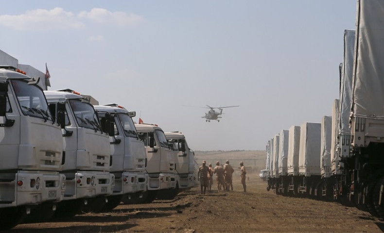 A military helicopter flies above the Russian convoy of trucks carrying humanitarian aid for Ukraine.