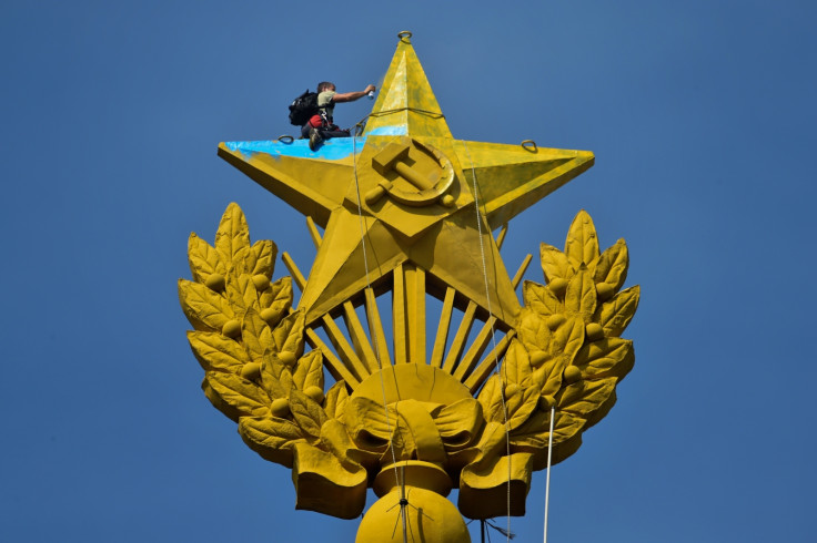 A worker paints over the star on Moscow's Stalin-era skyscraper. (AFP KIRILL KUDRYAVTSEV)