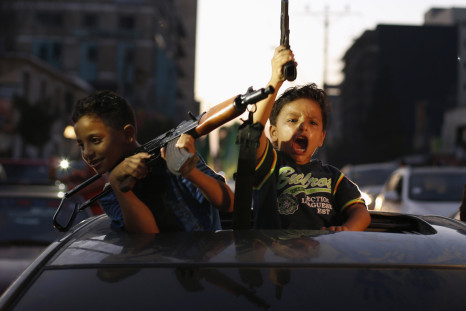 Young boys brandishing apparently real guns celebrate peace for Gaza in a Israel / Palestine ceasefire