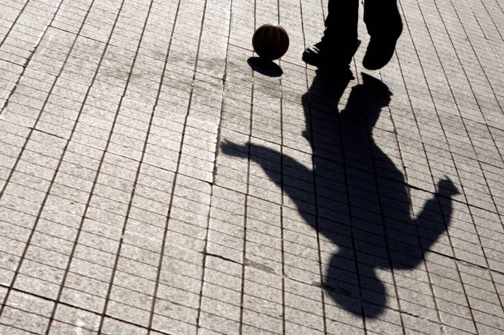 boy playing with ball in shadow