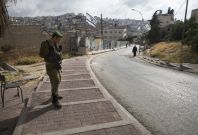 Israeli soldier guards a West Bank settlement