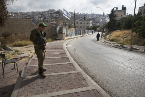Israeli soldier guards a West Bank settlement