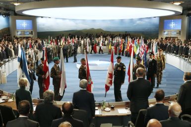 Leaders watch their flags as they participate in a NATO Summit Session One
