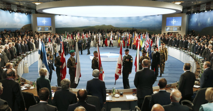 Leaders watch their flags as they participate in a NATO Summit Session One