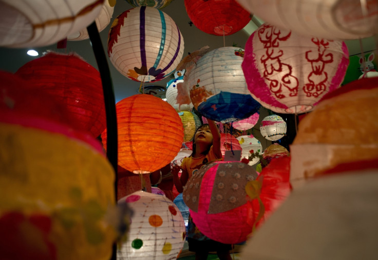 A child plays amongst multi-coloured paper lanterns put up to celebrate Mid-Autumn Festival in Malaysia
