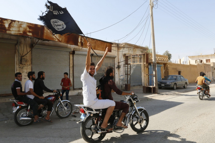 A resident of Tabqa city touring the streets on a motorcycle waves an Islamist flag in celebration after Islamic State militants took over Tabqa air base