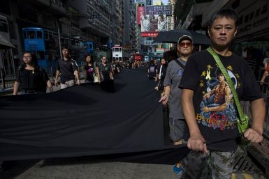 Pro-democracy activists march through the streets of Hong Kong carrying a 500-metre long black cloth.