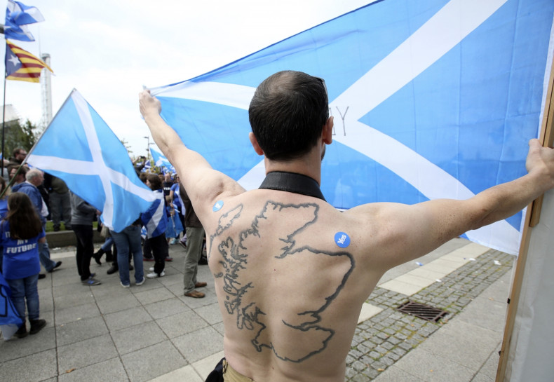 A 'Yes' supporter with a tattoo of Scotland on his back holds a Saltire flag at a rally outside the BBC in Glasgow, Scotland September 14, 2014.