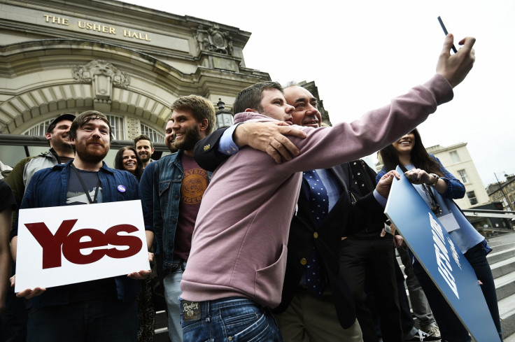 Scotland's First Minister Alex Salmond poses for a selfie with a fan, as he stands with local pop stars during an event in Edinburgh, Scotland September 14, 2014