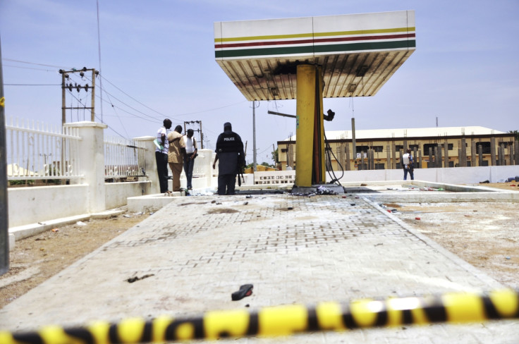 Members of the bomb squad inspect a Nigerian National Petrolium Corporation (NNPC) petrol station after a female suicide bomber blew herself in the city of Kano July 28