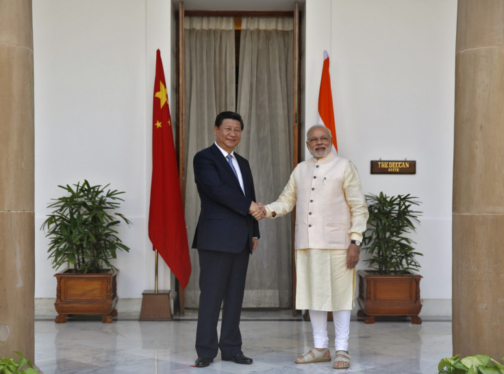 India's Prime Minister Narendra Modi (R) and China's President Xi Jinping shake hands during a photo opportunity ahead of their meeting at Hyderabad House in New Delhi