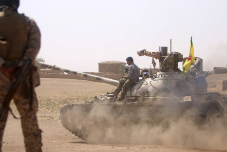 Kurdish People's Protection Units (YPG) drive a tank in villages surrounding Jazaa, in Qamishli countryside