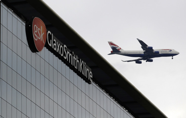 A British Airways airplane flies past a signage for pharmaceutical giant GlaxoSmithKline (GSK) in London