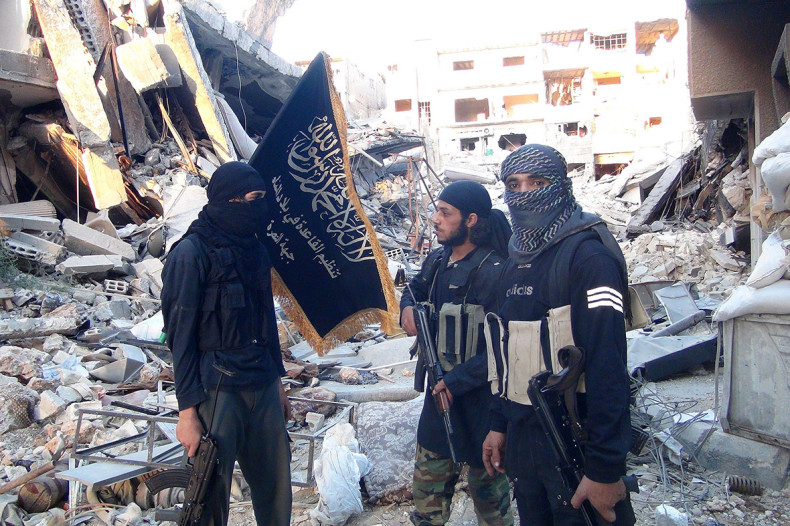 Fighters from the Nusra Front stand amid destroyed buildings in the south of Damascus, Syria