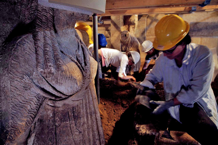 Excavating the caryatid statues from several feet of sandy soil