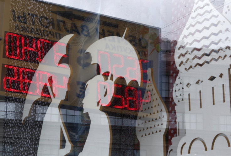 A board displaying currency exchange rates is reflected in a shop window in central Moscow