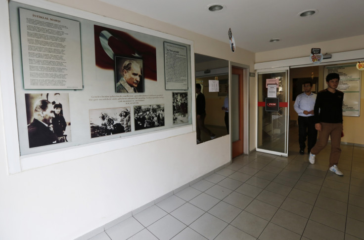 Students walk past photographs of modern Turkey's secular founder Mustafa Kemal Ataturk hanging on a wall at the entrance of FEM University Preparation School in Uskudar