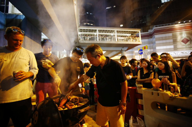 A man cooks sausages for protesters, who are blocking the main street to the financial Central district, outside the government headquarters in Hong Kong September 29, 2014