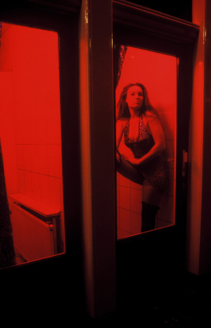 A Dutch prostitute sits behind her window in the red light district in Amsterdam, The Netherlands