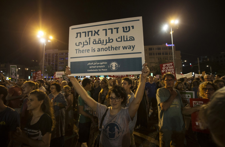 A woman holds up a placard during a peace rally in Tel Aviv's Rabin Square August 16, 2014.