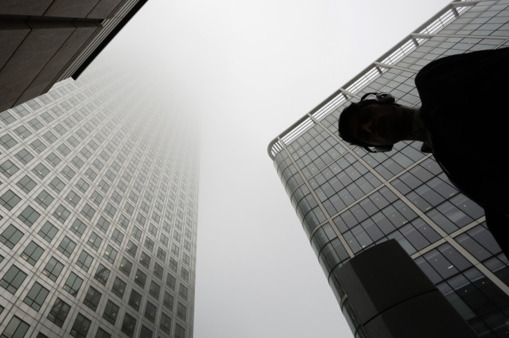 A man walks past a building in the morning mist at London's financial district of Canary Wharf September 16, 2014