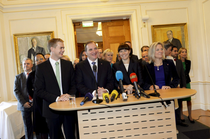 Swedish Prime Minister Stefan Lofven (front 2nd L) smiles as he stands with his new government during a news conference in Stockholm