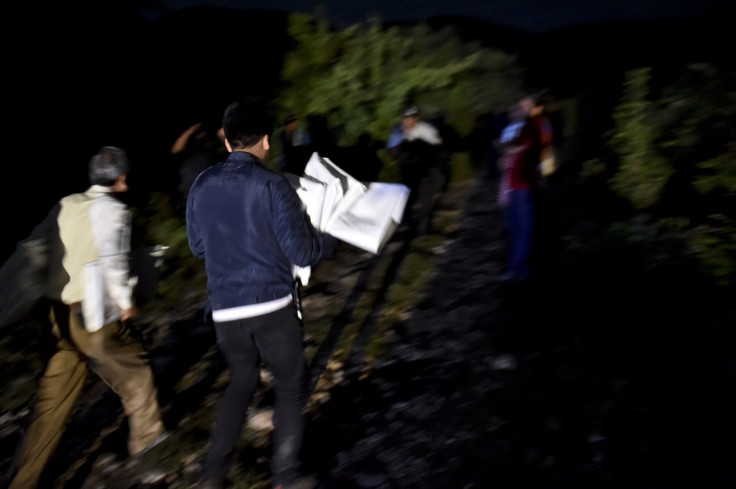 Officers bring body bags to the mass grave uncovered in Iguala last night. (AFP)