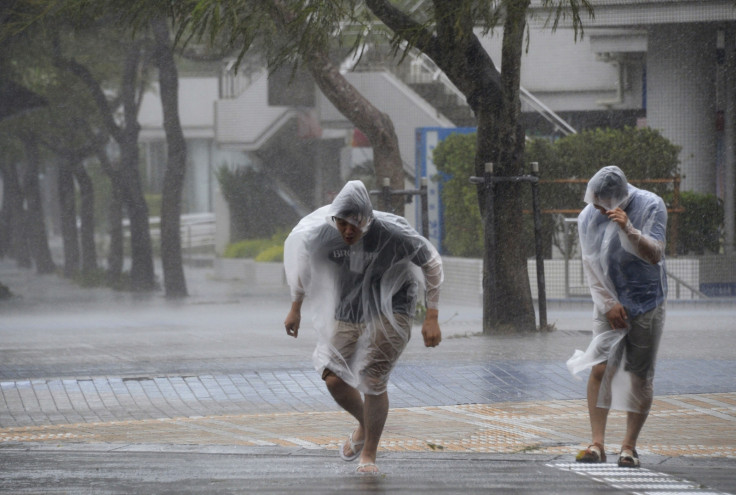 People struggle against strong wind and rain caused by Typhoon Vongfong on Japan's southern island of Okinawa