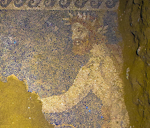 An unknown bearded man who wears the laurel wreath of a king or god in the mosaic