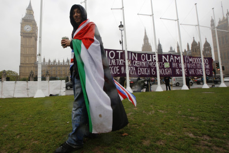 A pro-Palestine supporter wears a Palestinian and Union flag outside the Houses of Parliament in London