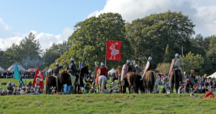 The Normans surround the bodies of the dead Anglo-Saxon army, proudly holding Harold's Anglo-Saxon flag aloft