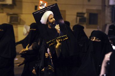 A protester holds up a picture of Sheikh Nimr al-Nimr during a rally at the coastal town of Qatif, against Sheikh Nimr's arrest