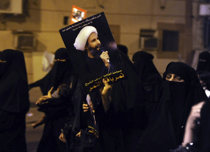 A protester holds up a picture of Sheikh Nimr al-Nimr during a rally at the coastal town of Qatif, against Sheikh Nimr's arrest