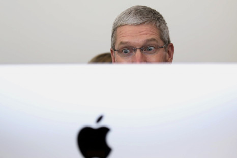 Apple CEO Tim Cook looks at a new IMac after a presentation at Apple headquarters in Cupertino, California October 16, 2014