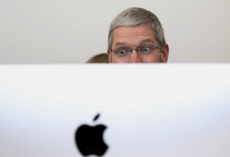 Apple CEO Tim Cook looks at a new IMac after a presentation at Apple headquarters in Cupertino, California October 16, 2014