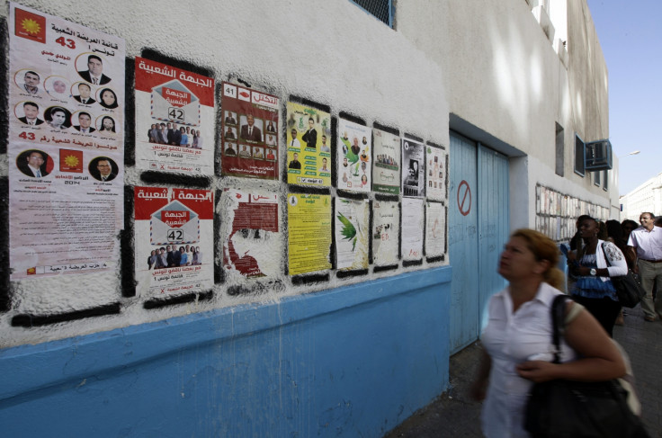 People look at parliamentary election posters in Tunis