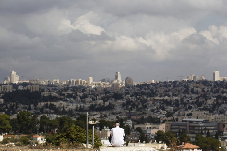 A view of Jerusalem is seen in the background as a man sits in Givat HaMato