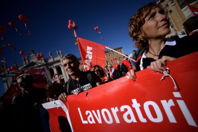 Protestors holding a banner arrive in San Giovanni square during a demonstration organised by Italian General Confederation of Labour (CGIL) union